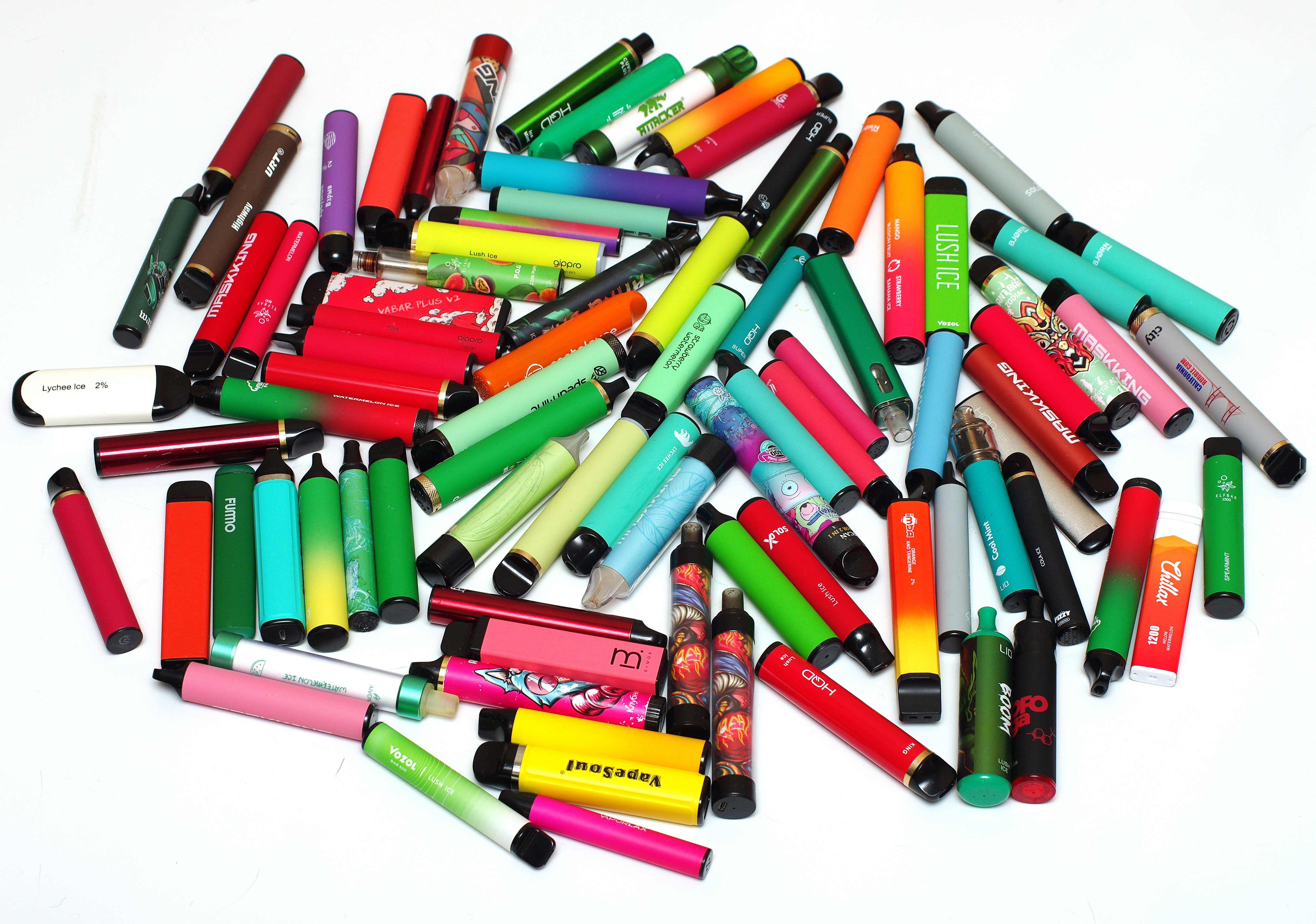 A pile of colorful disposable e-cigarettes (vapes) — the product class whose use among US high schoolers peaked in 2019 and has fallen sharply since.